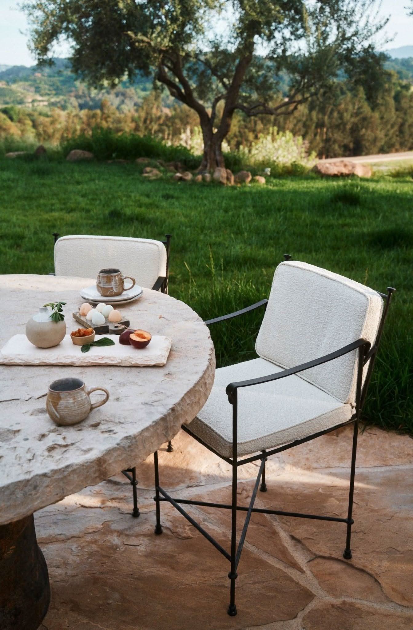 Outdoor Counter Stool - Boucle - Its delicate iron frame, finished in a durable matte-black powder coat, recalls the silhouettes of classic garden...