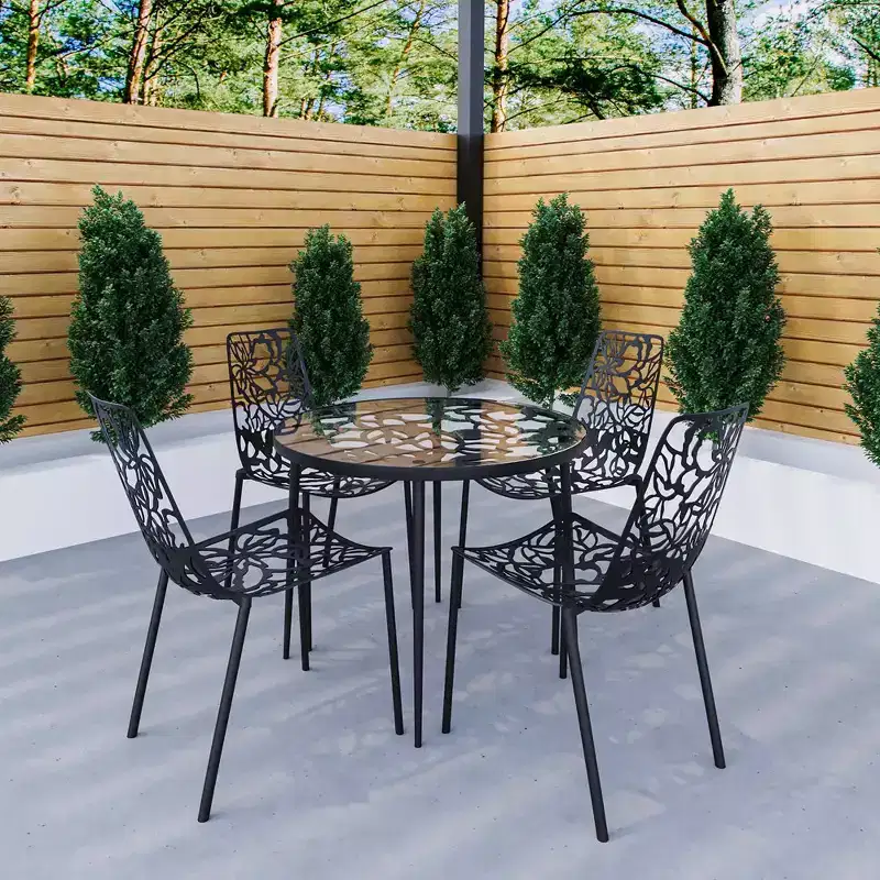 LeisureMod Devon 5-Piece Outdoor Dining Set - Round Glass Table with 4 Black Flower Design Stackable Chairs