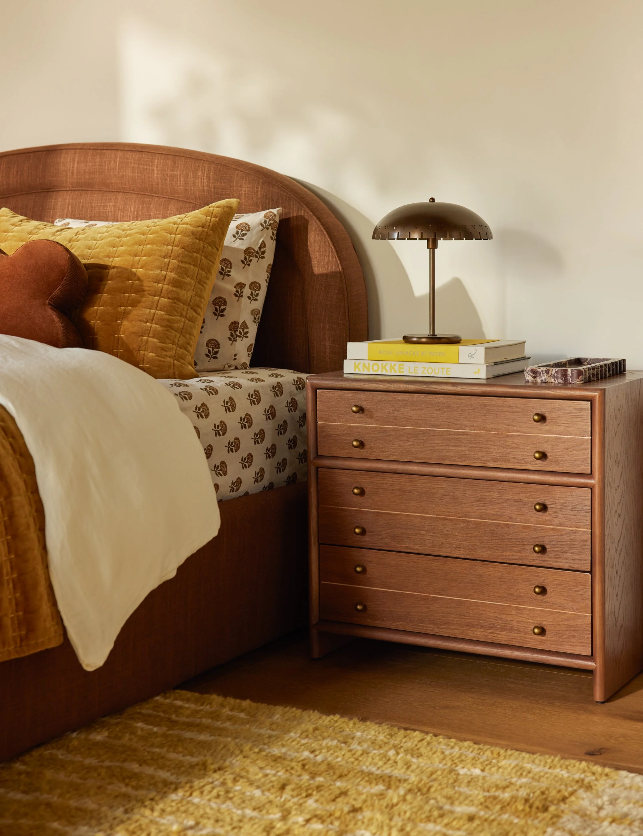 Nightstand Our nightstand brings a timeless touch to your bedside. The clean frame is crafted from wood, with rounded edging and slender brass